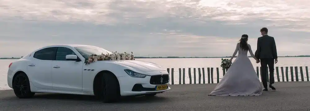 Trouwauto met bruid en bruidegom