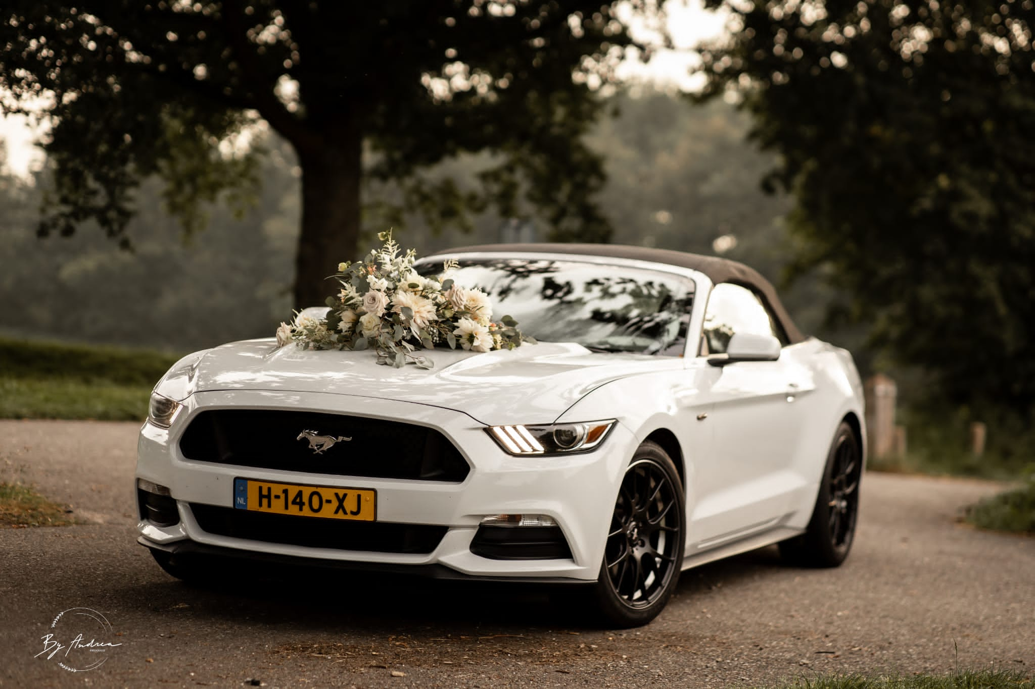 Bruidsboeket op trouwauto - boeket op motorkap trouwauto