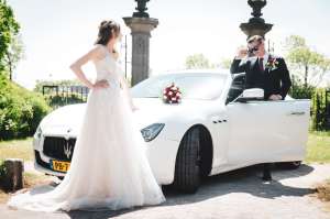 Witte Maserati trouwauto met bruid en bruidegom
