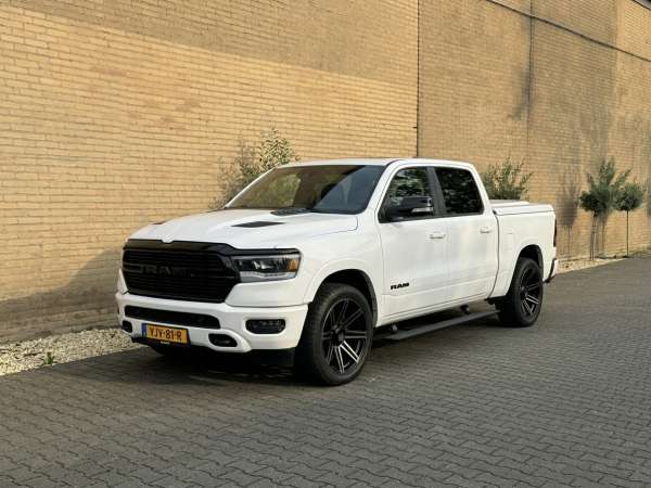 Witte Dodge RAM pick-up met zwarte velgen, schuin van voren gezien, te huur als trouwauto