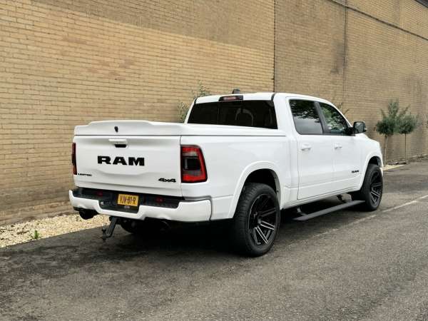 Witte Dodge RAM trouwauto van schuin achteren met laadklep en zwarte achterlichten
