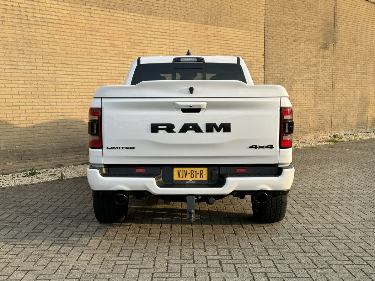 Achterkant van de witte Dodge RAM trouwauto met groot RAM-logo op de laadklep